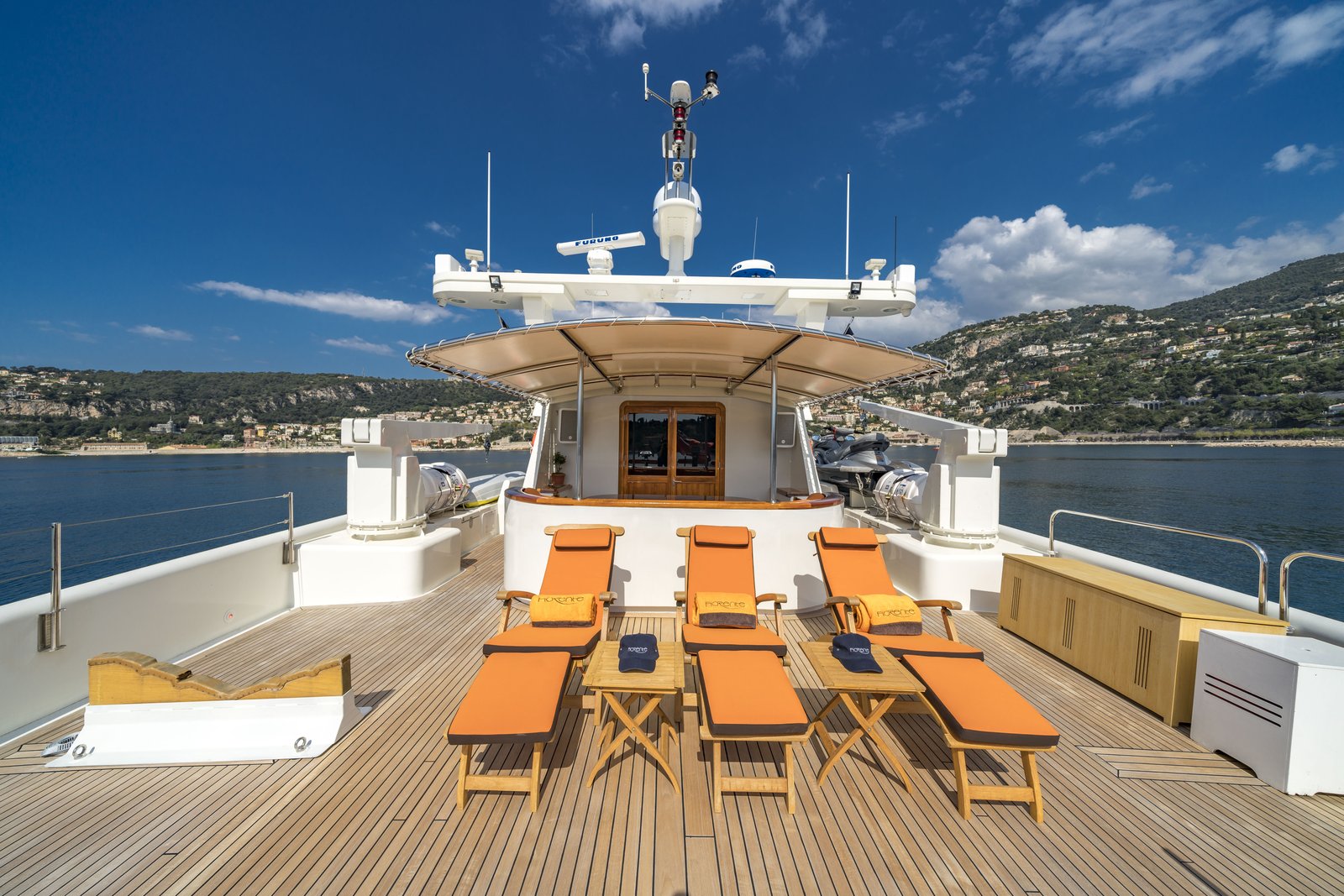 Aft deck dining alcove with oval table — orange banquette and Côte d'Azur views