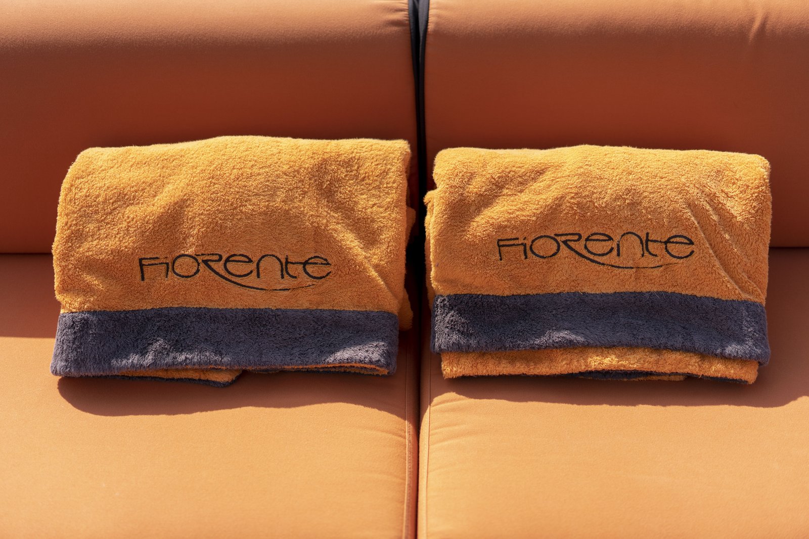 Bow sunpad with Fiorente towels — tender moored astern, Côte d'Azur beyond