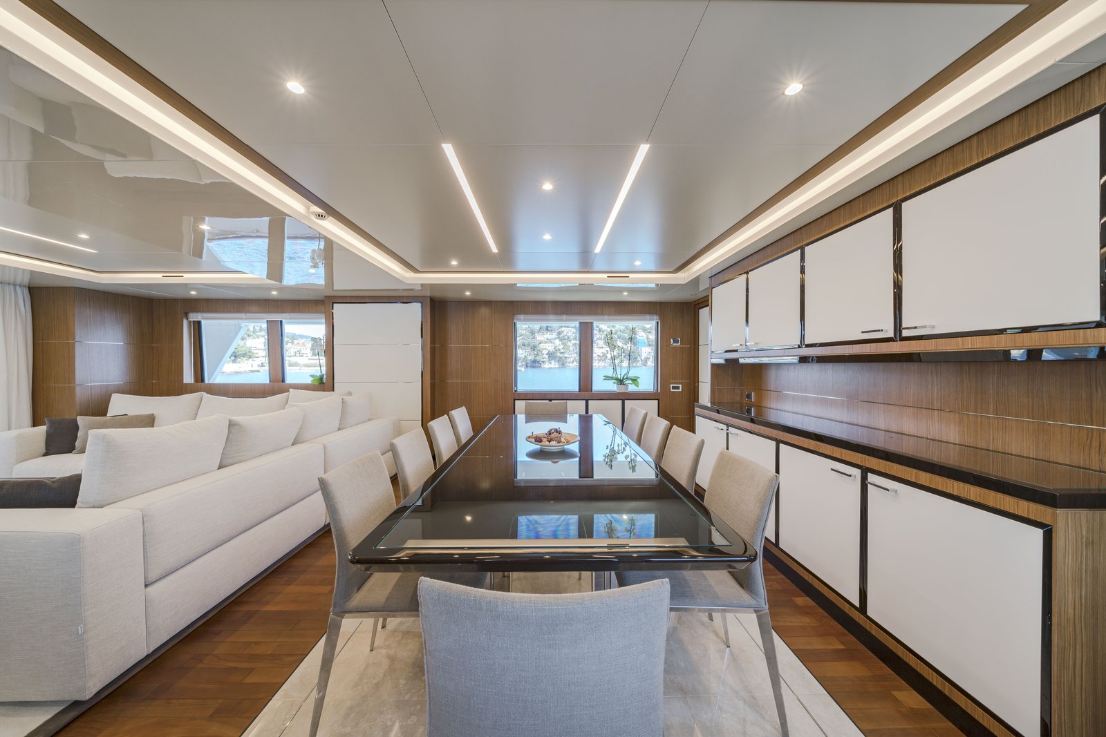 Fiorente's formal dining salon — 8-seat glass table with salon and Côte d'Azur windows beyond