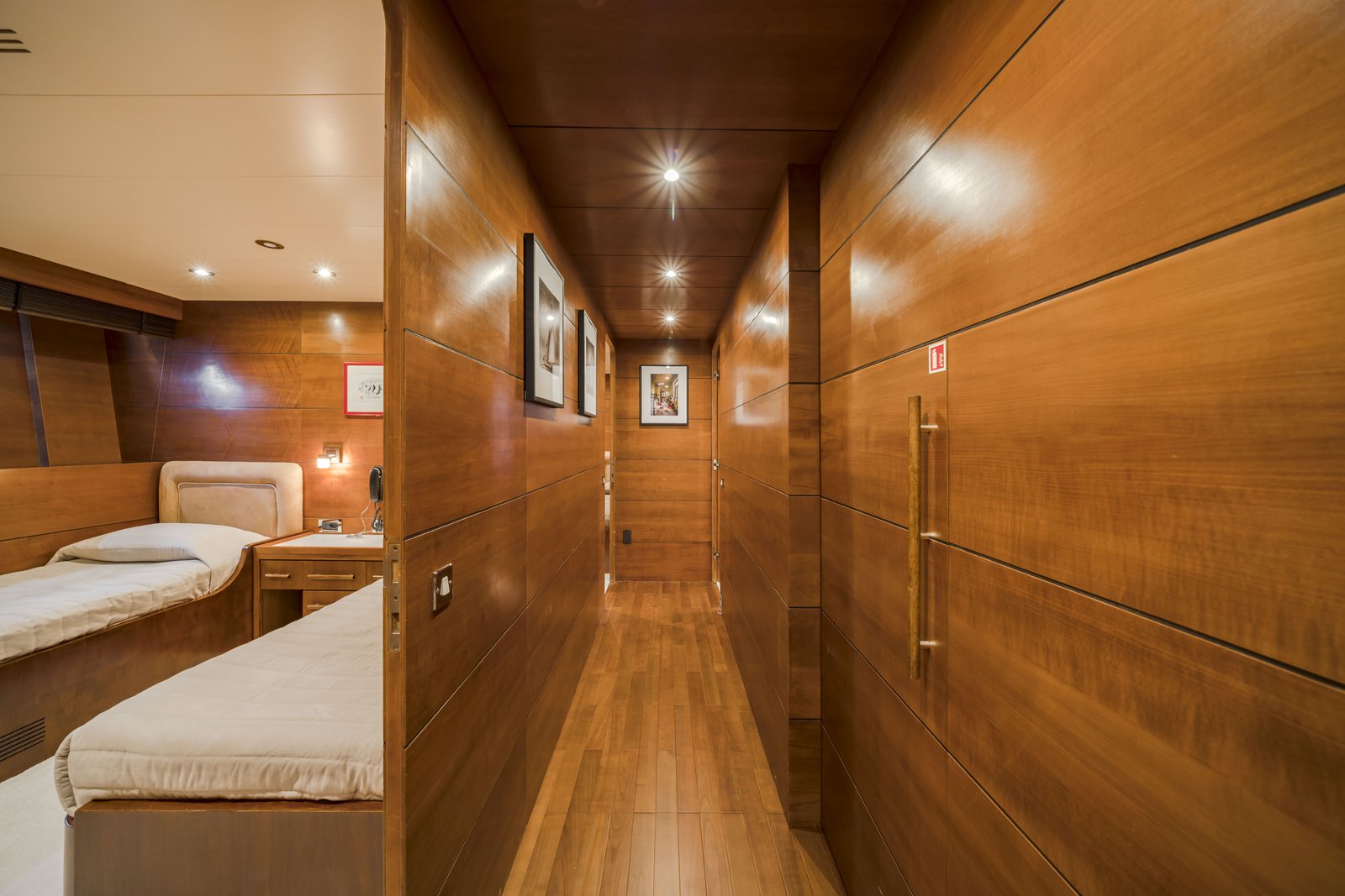 Guest deck corridor — warm cherry panelling, companionway to upper decks