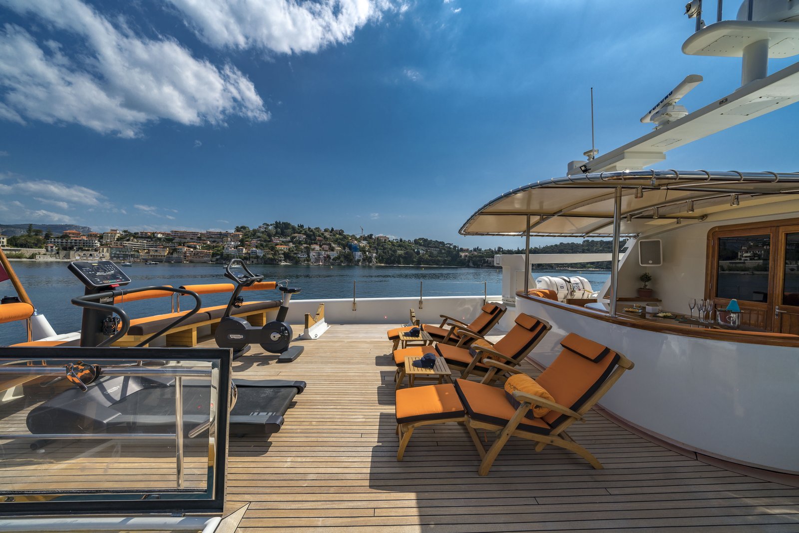 Upper-deck bar and lounge — champagne flutes and coastline views